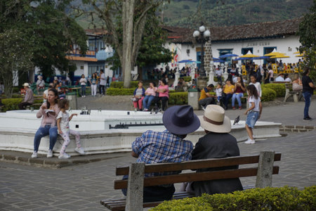 Two gentlemen having a conversation in the Parque Principal El Libertador, main square of Jardin, Eje Cafetero, Colombia 2020のeditorial素材