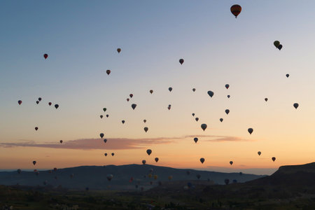 Dozens of hot air balloons rising over the landscape of the Red Valley, Rose Valley before sunrise, close to Goreme, Cavusin, Cappadocia, Turkey 2022の写真素材