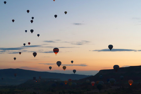 Many hot air balloons rising over the landscape of the Red Valley, Rose Valley before sunrise, close to Goreme, Cavusin, Cappadocia, Turkey 2022の写真素材