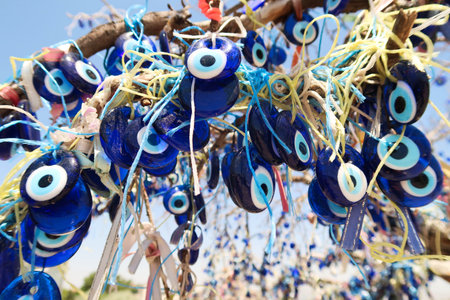 Close up on the many blue glass eyes hanging from the evil eye tree next to the Pigeon Valley, Gの写真素材