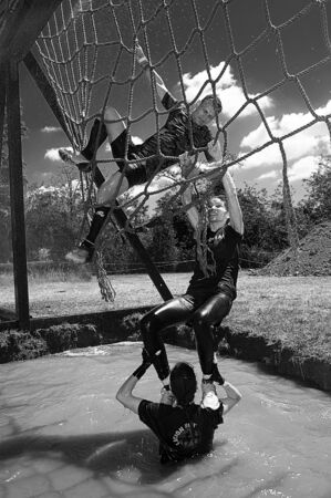 young men climbing on an obstacle during a competitionのeditorial素材
