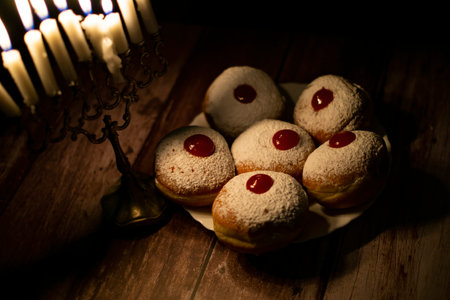 hanukkah candle on wooden background with donutsの写真素材