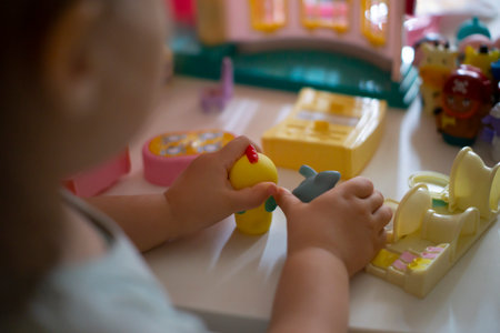 Cute little girl playing with toys in the children's room.の写真素材