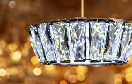 Modern crystal chandelier with suspension on bokeh background.の写真素材