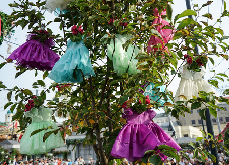Installation with hanging children's dresses on the tree.の写真素材