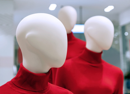Mannequins in red sweaters in the interior of a clothing store.の写真素材