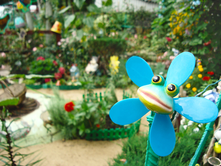 Toy frog on the background of a blooming summer garden.の写真素材