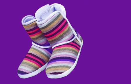 Woolen uggs with colored stripes on a purple background.の写真素材