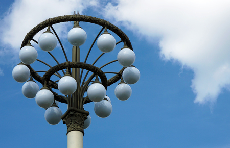 Street lamp with white round shades on a blue sky background.の写真素材