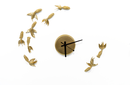 Quartz clock with goldfish on a white wall.の写真素材