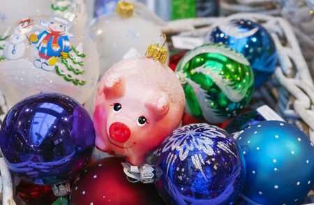 Christmas glass toy pink piggy among colorful balloons.の写真素材