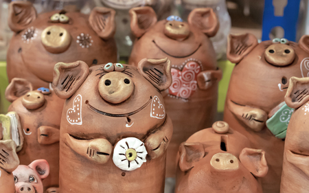 Brown ceramic piggy banks with painted hearts.の写真素材