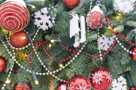 The Christmas tree on the street is decorated with various bright toys and snowflakes.
