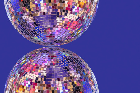 Disco ball with symmetrical reflection on a purple background.