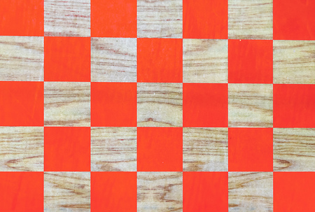Wooden chessboard with orange cells. Checkerboard background.の写真素材