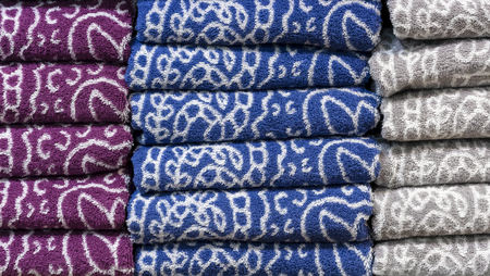 Folded terry towels on the counter of the store. Background towels.