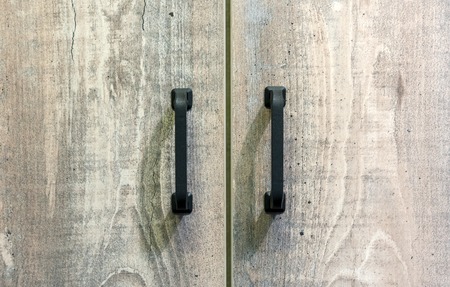 Furniture black handles on wooden doors. Background for design and decoration.の写真素材