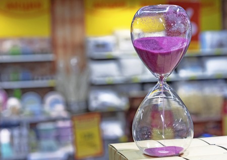 Hourglass with purple sand to measure time. Vintage hourglass.
