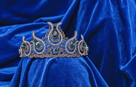 Diadem with green stones on a blue velvet background. Eastern tiara. Jewelry design.の写真素材