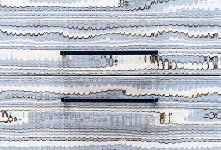 Gray wavy wooden texture with black furniture handles. Wood background for design and decoration.
