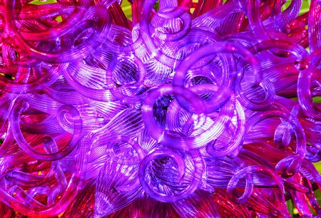 Glass chandelier with curls and red-purple glow.の写真素材