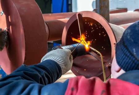 Welder is welding metal structures on a new gas pipeline.