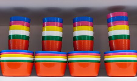 Multi-colored plastic glasses and plates for a picnic in nature.