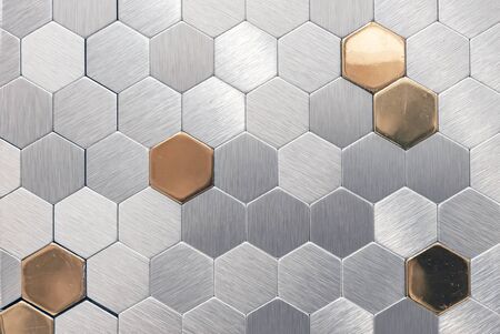 Silver? metal mosaic tile with golden elements. Metal mosaic in the form of honeycombs.