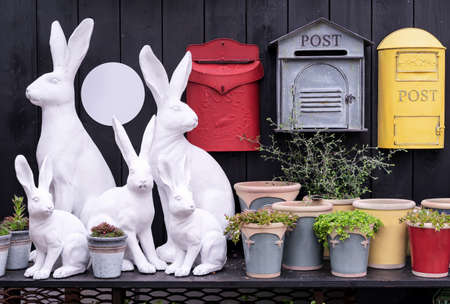 Garden decorations in the form of plaster bunnies, ceramic flower pots and metal mailboxes.