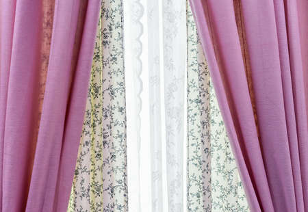 Pink curtains and white lace tulle on the living room window.の写真素材