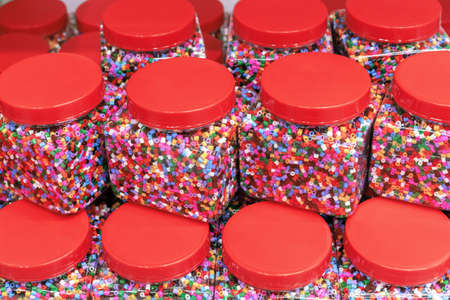 Many transparent jars with multi-colored thermo-mosaic beads for children's creativity.