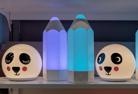Children's night lamps in the shape of a dog's face and pencils with a multi-colored glow.の写真素材