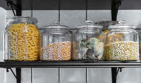 Kitchen glass jars with cereals, pasta and laurel leaves.の写真素材