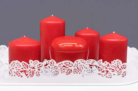 Red Christmas candles in a white openwork cachepot. New Year's decor with candles.の写真素材