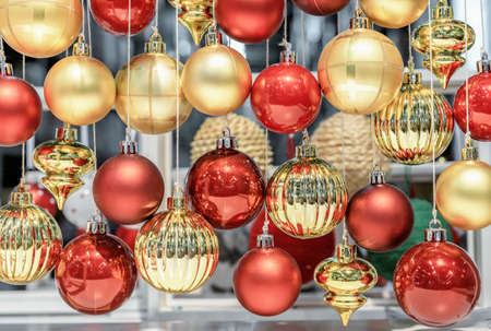 Red and yellow glass Christmas balls hanging on threads.の写真素材