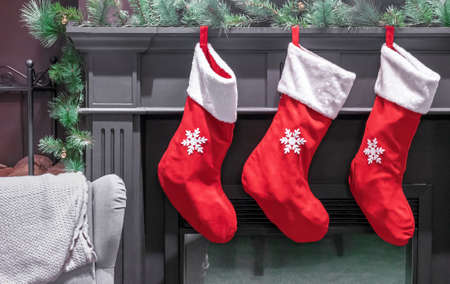 Three red Christmas stockings for gifts over the fireplace in the living room.