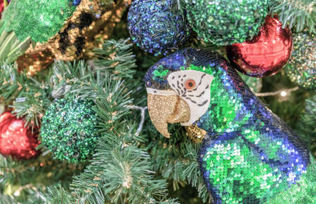 Macaw parrot with blue and green sequins and gold beak on the Christmas tree.の写真素材