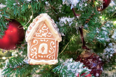 Gingerbread house with white icing on the Christmas tree.の写真素材