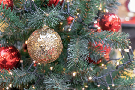 Gold Christmas ball with sparkles and bugles on the Christmas tree.の写真素材