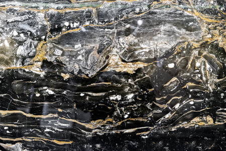Black quartz stone with white and yellow stripes. Natural quartz background and texture.の写真素材