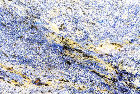 Natural blue granite with yellow and black splashes. Granite background.の写真素材