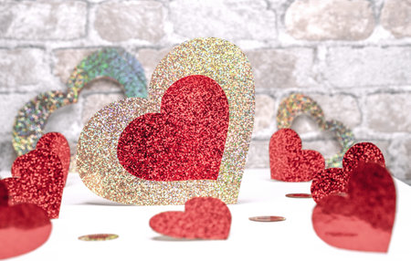 Red-gold shiny hearts on a brick wall background. Valentine's Day concept.の写真素材