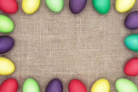 Multicolored Easter eggs on a burlap background. Easter frame.の写真素材