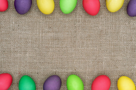 Multicolored Easter eggs on a burlap background. Easter frame.の写真素材