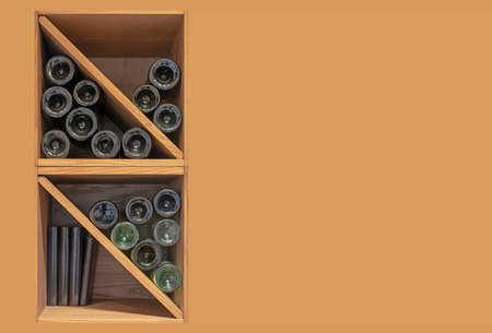 Bottles of red and white wine on wooden shelves. Storage of alcohol.の写真素材