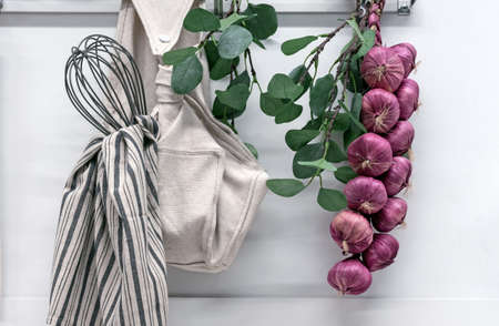 Heads of garlic tied in a bunch hang in the kitchen.の写真素材