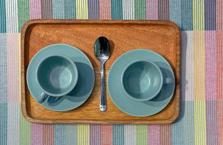 Two turquoise coffee cups on a wooden tray.の写真素材