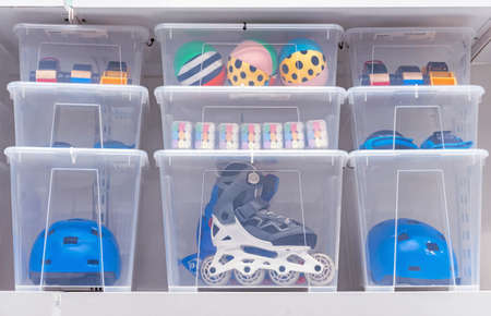 Plastic boxes with children's toys, rollers and a helmet.の写真素材
