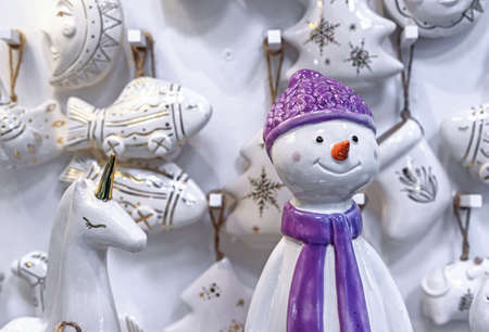 Ceramic statuette of a snowman in a purple hat and scarf.の写真素材