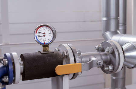 Manometer and thermometer for measuring the temperature and pressure of water in the plumbing system at a gas boiler room.の写真素材